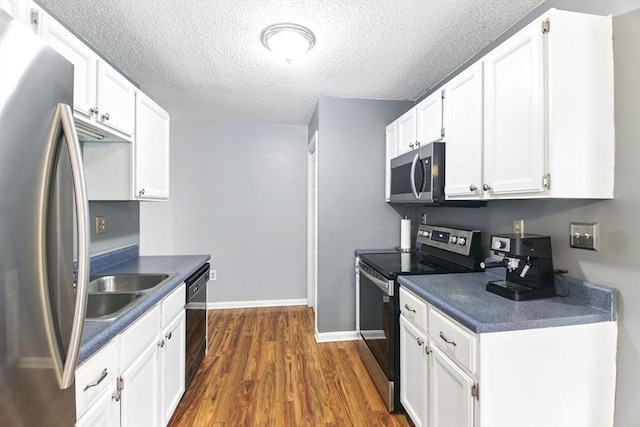 59 Castlegate Dr Unit B, Springfield, MA 01129 - kitchen with stainless steel appliances, dark countertops, dark wood finished floors, white cabinets, and a textured ceiling