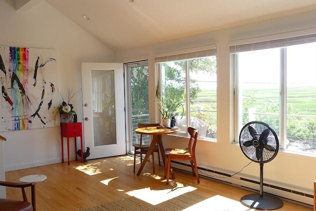 sunroom featuring lofted ceiling and a baseboard heating unit