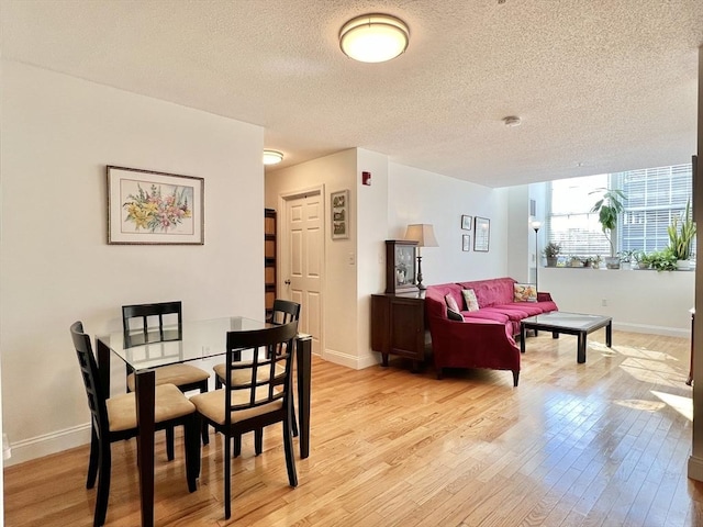 dining area featuring a textured ceiling and light wood-type flooring