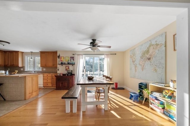 kitchen with light countertops, pendant lighting, light wood finished floors, dishwasher, and ceiling fan