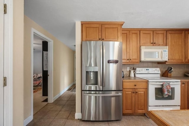 kitchen with white appliances, light countertops, decorative backsplash, and light tile patterned floors