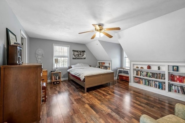 bedroom featuring dark wood finished floors, baseboards, vaulted ceiling, and a ceiling fan