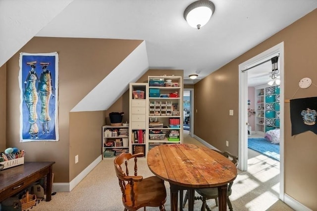 dining room featuring carpet flooring, baseboards, and vaulted ceiling