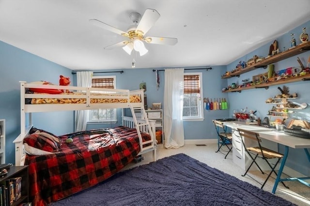 carpeted bedroom with a ceiling fan and baseboards