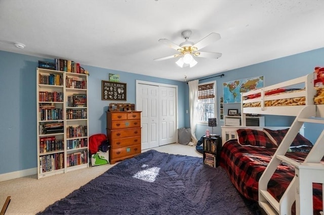 bedroom with a closet, carpet flooring, ceiling fan, and baseboards
