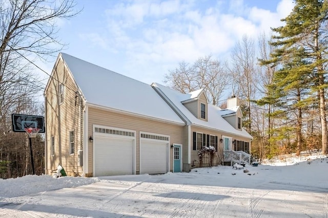 cape cod-style house featuring a garage and a chimney
