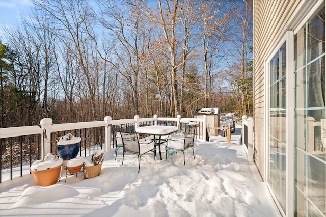 snow covered deck featuring outdoor dining area