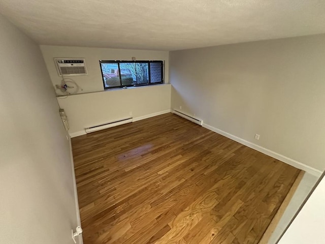 empty room with baseboards, baseboard heating, an AC wall unit, and dark wood-type flooring