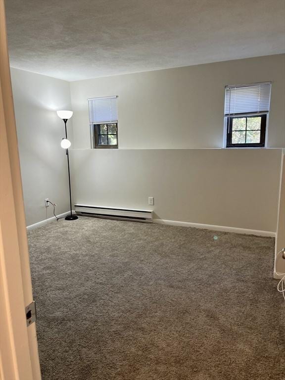 unfurnished room featuring carpet floors, a baseboard radiator, and baseboards
