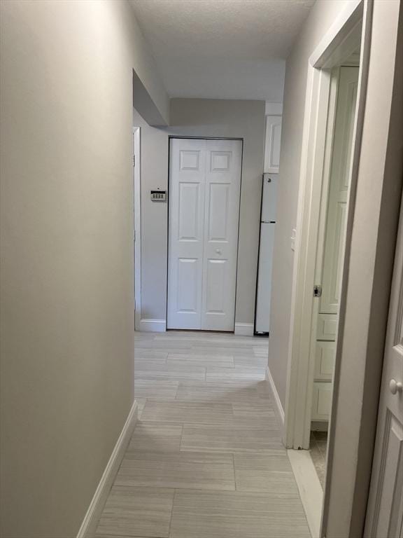 hall featuring baseboards