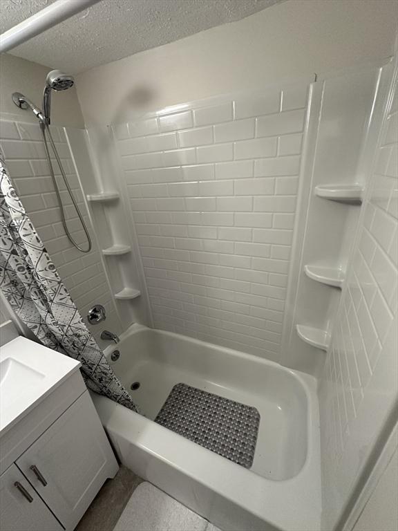 full bath featuring vanity and a textured ceiling