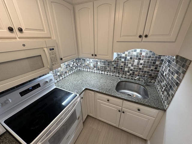 kitchen with a sink, white microwave, backsplash, and electric range