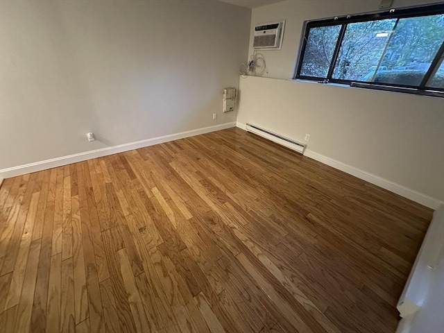 unfurnished room with baseboards, a wall mounted air conditioner, a baseboard heating unit, and wood finished floors