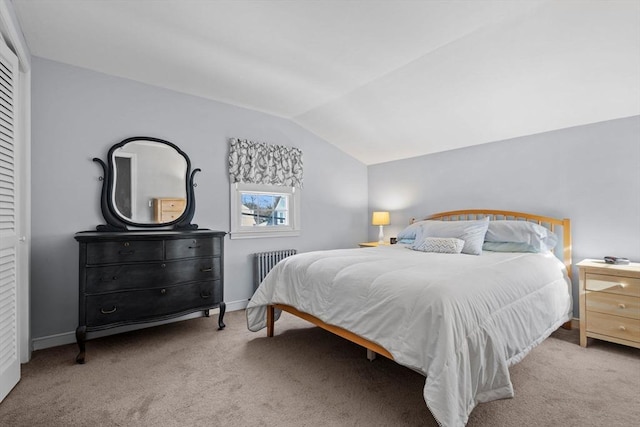 bedroom with radiator heating unit, vaulted ceiling, and light colored carpet