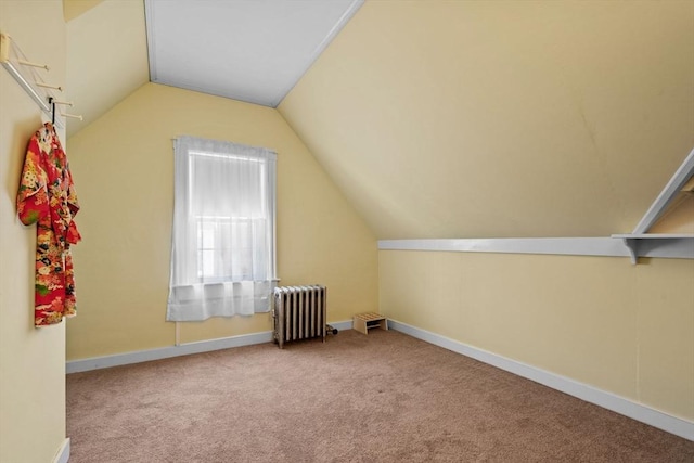 bonus room with lofted ceiling, radiator, and light colored carpet