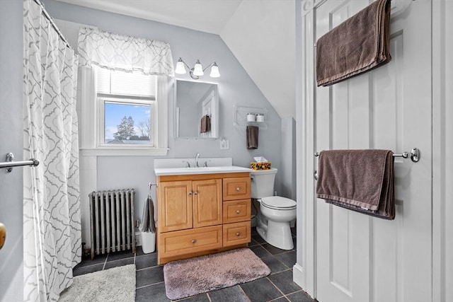 bathroom featuring tile patterned floors, toilet, vaulted ceiling, vanity, and radiator