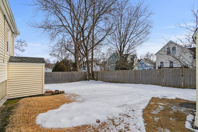 yard layered in snow with a storage shed