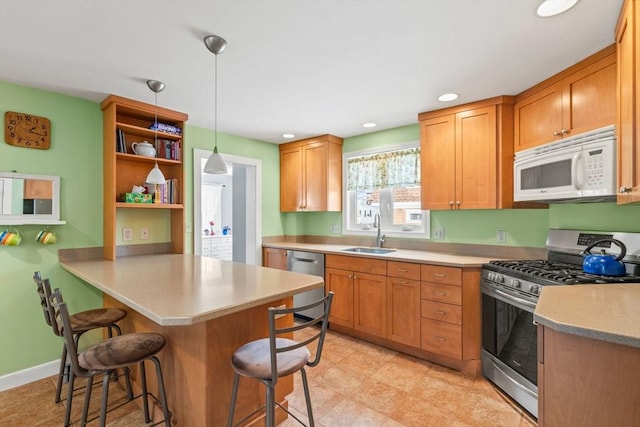 kitchen with sink, a breakfast bar area, hanging light fixtures, kitchen peninsula, and stainless steel appliances