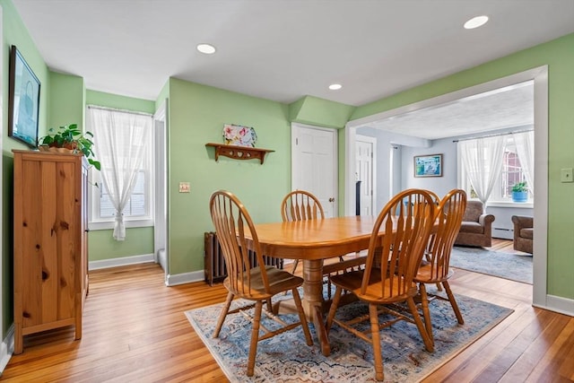 dining space featuring a baseboard heating unit and light wood-type flooring