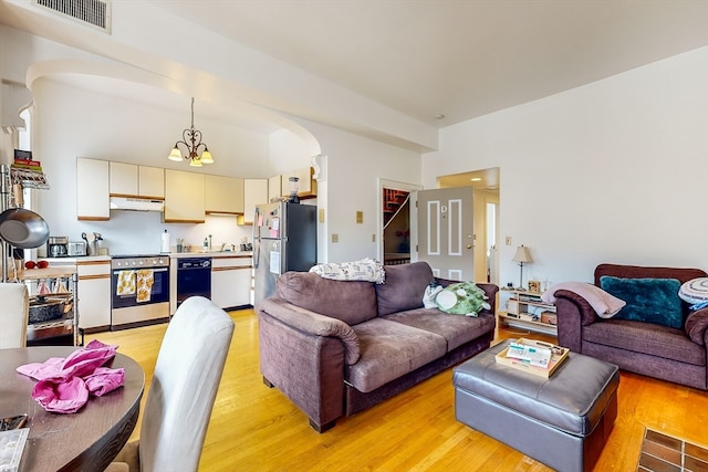 living room with a notable chandelier and light hardwood / wood-style floors