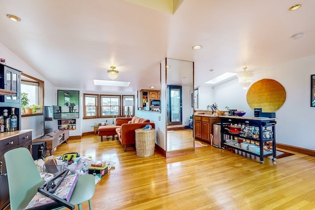 living room featuring plenty of natural light, a skylight, light hardwood / wood-style flooring, and a notable chandelier