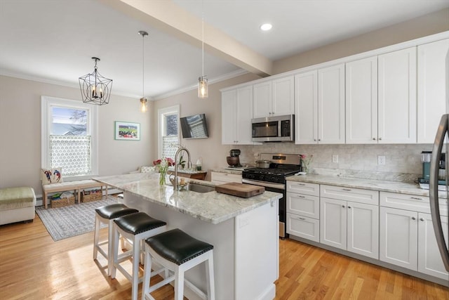 kitchen featuring white cabinetry, sink, an island with sink, and appliances with stainless steel finishes