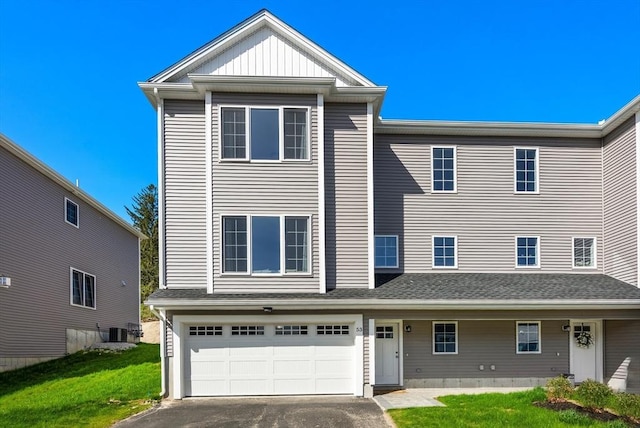 townhome / multi-family property with a garage, a front lawn, central air condition unit, and driveway