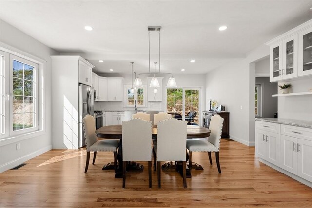 dining area featuring baseboards, light wood finished floors, and recessed lighting