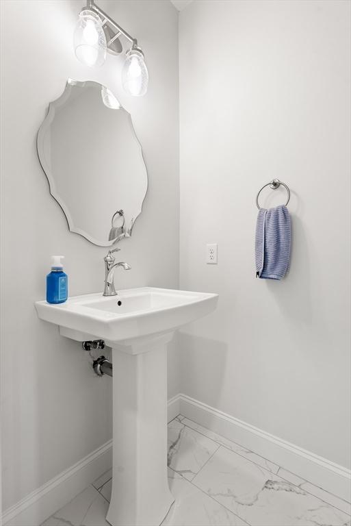 bathroom with baseboards and marble finish floor