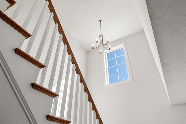 stairs featuring an inviting chandelier