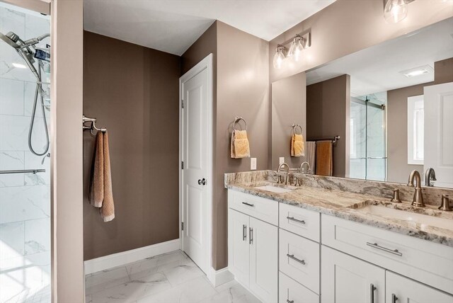 full bathroom with baseboards, a marble finish shower, a sink, and marble finish floor