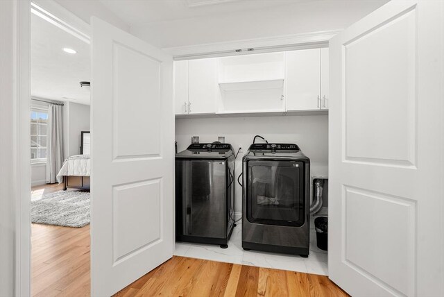 laundry area featuring cabinet space, recessed lighting, washer and clothes dryer, and light wood-style floors