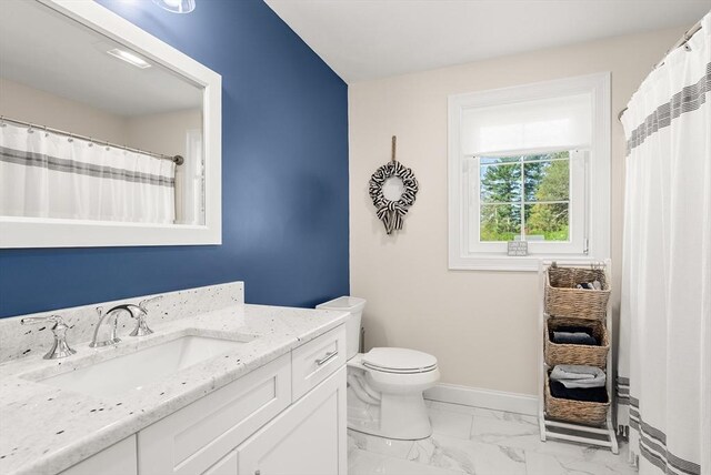 bathroom with baseboards, marble finish floor, toilet, and vanity