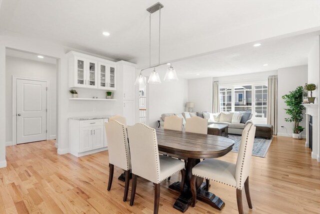 dining room with recessed lighting, baseboards, and light wood-type flooring