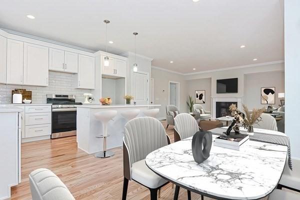 kitchen featuring white cabinetry, stainless steel range, a kitchen island, pendant lighting, and decorative backsplash