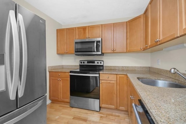 360 Neponset St Unit 503, Canton, MA 02021 - kitchen with stainless steel appliances, a sink, light wood-type flooring, and light stone countertops