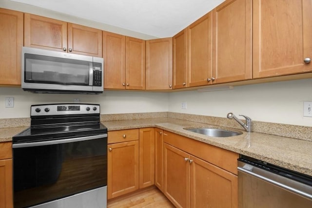360 Neponset St Unit 503, Canton, MA 02021 - kitchen featuring stainless steel appliances, a sink, light stone countertops, and light wood-style flooring