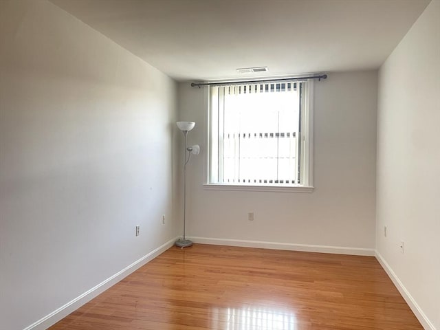 spare room with light wood finished floors and baseboards