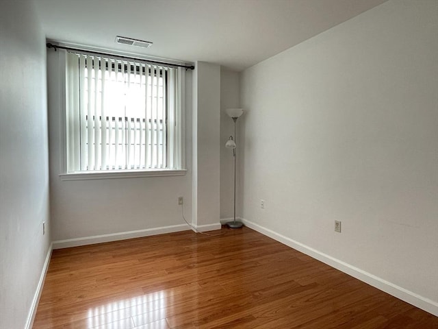 spare room with wood finished floors and baseboards