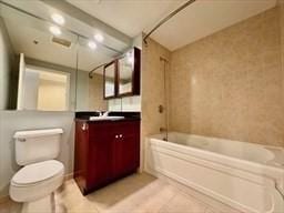 full bathroom featuring vanity, tiled shower / bath combo, tile patterned floors, and toilet