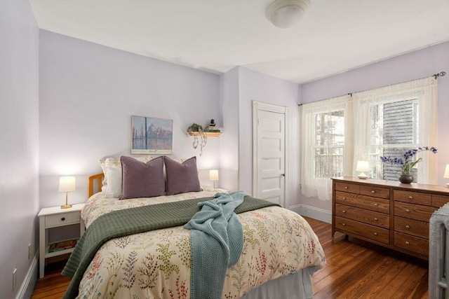 bedroom featuring a closet, baseboards, and dark wood-style floors