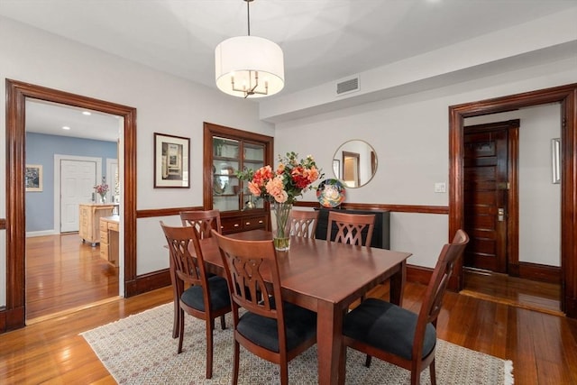 dining room with visible vents, baseboards, an inviting chandelier, and light wood-style flooring