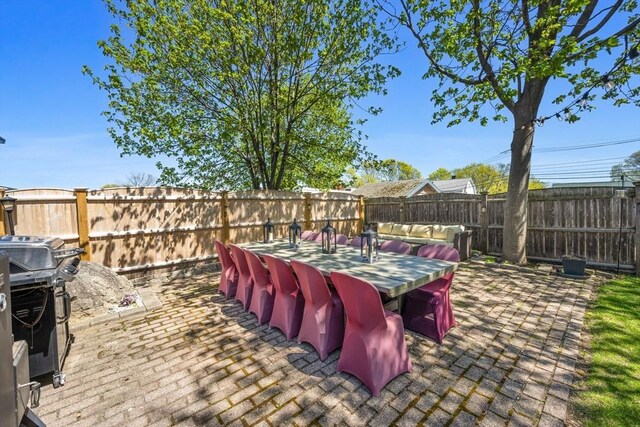 view of patio with a fenced backyard, outdoor dining area, and area for grilling