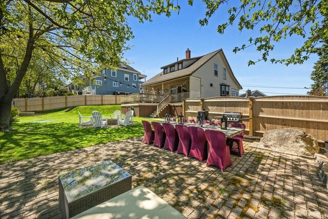 view of yard with stairs, an outdoor fire pit, a wooden deck, a fenced backyard, and a patio