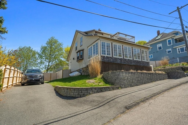 view of front of house featuring fence and a balcony