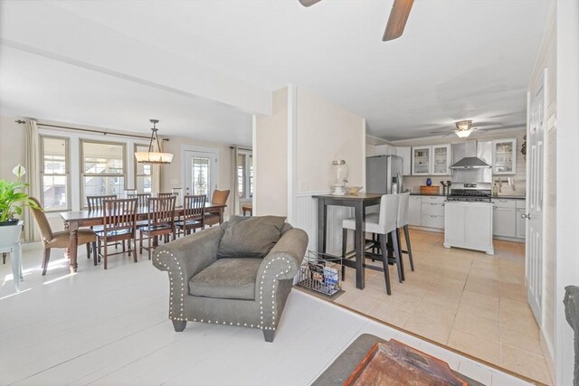 living area featuring ceiling fan and light tile patterned flooring