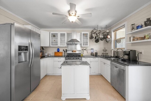 kitchen with a sink, dark countertops, stainless steel appliances, and wall chimney exhaust hood