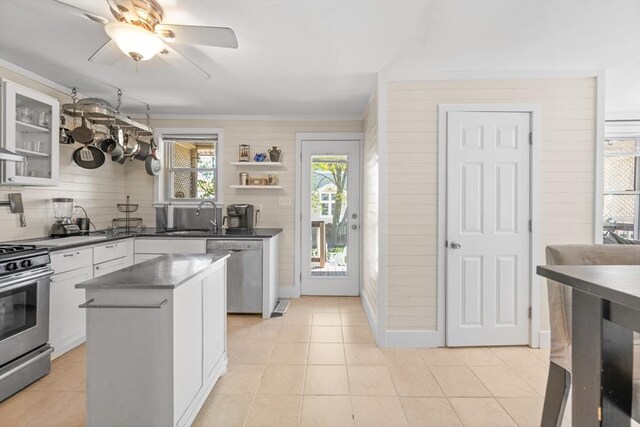 kitchen with dark countertops, ceiling fan, stainless steel appliances, white cabinetry, and backsplash