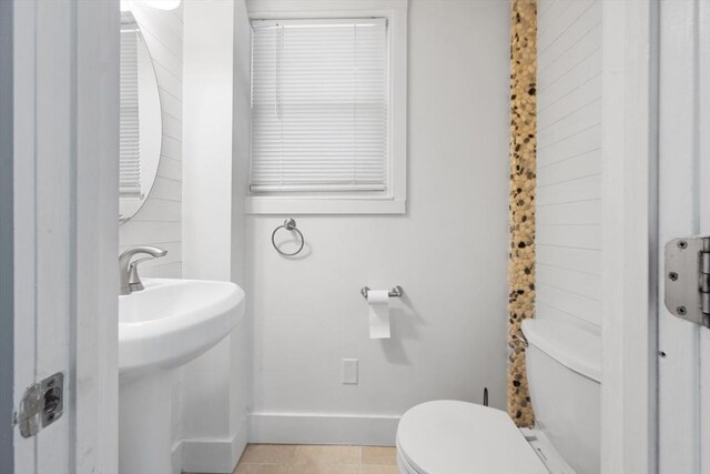 bathroom with baseboards, tile patterned floors, and toilet