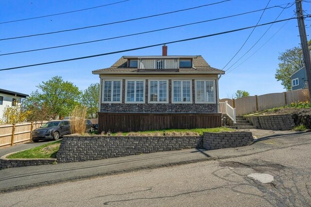 view of front of house with fence and stone siding
